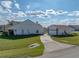 Exterior view of white home, showcasing its landscape, backyard pool, and two-car garage at 1301 Hidden Creek Ct, Winter Haven, FL 33880