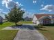 Charming home featuring a well-manicured lawn, mature tree and spacious driveway at 1301 Hidden Creek Ct, Winter Haven, FL 33880