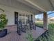 Inviting front porch with rocking chairs, brick flooring, and manicured landscaping for relaxing outdoors at 1301 Hidden Creek Ct, Winter Haven, FL 33880