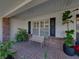 Charming front porch featuring a cozy bench, brick flooring, and black shutters for added curb appeal at 1301 Hidden Creek Ct, Winter Haven, FL 33880