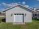 Close up of white two-car garage exterior with white siding and brick accents at 1301 Hidden Creek Ct, Winter Haven, FL 33880