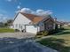 Side view of a two-car garage with white doors, brick accents, and an adjacent landscaped area at 1301 Hidden Creek Ct, Winter Haven, FL 33880