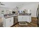 Stylish kitchen featuring stainless steel appliances, white cabinetry, and dark wood flooring at 1301 Hidden Creek Ct, Winter Haven, FL 33880