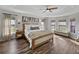 Spacious main bedroom featuring a tray ceiling, wood floors, and large windows at 1301 Hidden Creek Ct, Winter Haven, FL 33880