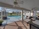 This patio is set up with ceiling fans, furniture and views of the enclosed pool and backyard at 1301 Hidden Creek Ct, Winter Haven, FL 33880