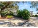 Paved driveway with brick trim and mature landscaping featuring tropical plants and a large oak tree at 14 Lake Hollingsworth Dr, Lakeland, FL 33803