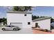 Modern home with an attached garage, a manicured yard, and a silver car parked in the driveway at 14 Lake Hollingsworth Dr, Lakeland, FL 33803