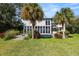 Exterior view of the home with a spacious yard, deck, and large windows offering ample natural light at 14 Lake Hollingsworth Dr, Lakeland, FL 33803