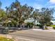 Street view of the property showcasing mature trees, landscaping, and glimpses of the lake at 14 Lake Hollingsworth Dr, Lakeland, FL 33803