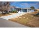 Exterior of blue home with screened-in porch, carport, driveway and landscaping at 140 Jackson Park Ave, Davenport, FL 33897