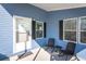 Cozy front porch with seating, light blue siding, and black window shutters at 140 Jackson Park Ave, Davenport, FL 33897