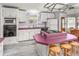 A kitchen features white cabinets, a pink countertop, an island, and wood floors at 140 Jackson Park Ave, Davenport, FL 33897