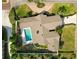 Aerial view of a property showcasing a well-manicured lawn, swimming pool, and circular driveway with lush greenery at 1401 Easton Dr, Lakeland, FL 33803