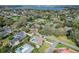 Expansive aerial view showcasing the neighborhood's lush landscaping, swimming pools, and a glimpse of the distant lake at 1401 Easton Dr, Lakeland, FL 33803