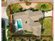 Aerial view of a property showcasing a well-manicured lawn, swimming pool, and circular driveway with lush greenery at 1401 Easton Dr, Lakeland, FL 33803