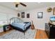 Bedroom with a blue bedspread, black metal frame, fan, and wooden floors at 1401 Easton Dr, Lakeland, FL 33803