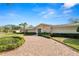 Inviting home with a brick driveway, manicured landscaping, and a stone facade exudes timeless charm and curb appeal at 1401 Easton Dr, Lakeland, FL 33803