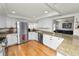 Bright kitchen showcasing white cabinets, stainless steel appliances, and a view into the living area at 1401 Easton Dr, Lakeland, FL 33803