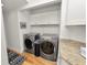 Modern laundry room with front-load washer and dryer, stylish flooring and white cabinets at 1401 Easton Dr, Lakeland, FL 33803