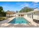 Backyard pool with brick paver surround, outdoor kitchen, and white fence at 1401 Easton Dr, Lakeland, FL 33803