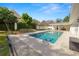 A beautiful backyard pool with landscaped yard, adjacent patio, and full outdoor kitchen at 1401 Easton Dr, Lakeland, FL 33803