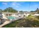 A beautiful backyard pool with brick paver surround, landscaped yard, and outdoor kitchen at 1401 Easton Dr, Lakeland, FL 33803