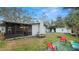 Landscaped backyard featuring a fire pit, picnic table, and screened porch at 1632 Sims Pl, Lakeland, FL 33803