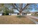 Exterior of a charming white brick home with a swing under a shade tree at 1632 Sims Pl, Lakeland, FL 33803