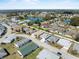 Aerial view of a residential area featuring various houses, streets, and a scenic pond at 1957 Prairie Dunes N Cir, Lakeland, FL 33810