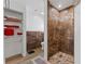 Bathroom with marble walk-in shower, seat, shelves, and tiled floor next to toilet and towel storage shelf at 1957 Prairie Dunes N Cir, Lakeland, FL 33810