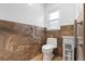 Bathroom featuring decorative brown-tiled wall accents, a modern toilet, white cabinet and handrail at 1957 Prairie Dunes N Cir, Lakeland, FL 33810