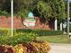 Exterior view of the community sign 'Highland Fairways' surrounded by colorful flowers and greenery at 1957 Prairie Dunes N Cir, Lakeland, FL 33810