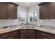 Bright kitchen features granite countertops, stainless steel sink, and stylish dark wood cabinetry at 1957 Prairie Dunes N Cir, Lakeland, FL 33810