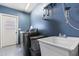 Functional laundry room with modern washing machine, utility sink, and speckled flooring at 1957 Prairie Dunes N Cir, Lakeland, FL 33810