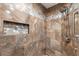 Detail of modern walk-in shower featuring marble patterned tiles, mosaic tile accents, and an adjustable shower head at 1957 Prairie Dunes N Cir, Lakeland, FL 33810