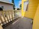 Cozy balcony area with wooden railing, offering a relaxing outdoor space, with yellow siding at 2015 E Beacon By Way, Lakeland, FL 33803