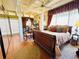 A cozy bedroom featuring a dark wooden sleigh bed, hardwood floors and a ceiling fan and exposed beams at 2015 E Beacon By Way, Lakeland, FL 33803