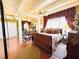 A cozy bedroom featuring a dark wooden sleigh bed, hardwood floors and a ceiling fan and exposed beams at 2015 E Beacon By Way, Lakeland, FL 33803