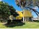 Charming home with vibrant yellow exterior and lush landscaping at 2015 E Beacon By Way, Lakeland, FL 33803