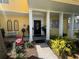 Inviting front entrance with a yellow facade, stone pathway, and decorative columns at 2015 E Beacon By Way, Lakeland, FL 33803