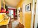 Hallway with decorative rugs, yellow walls, and open doorways creates an inviting and visually appealing space at 2015 E Beacon By Way, Lakeland, FL 33803