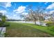 Expansive backyard with lush green grass leading to a serene lake view and mature trees at 2038 Winterset Dr # 2038, Lakeland, FL 33813