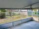 This screened back porch offers views of the backyard with a ceiling fan at 209 Ann Ave, Dundee, FL 33838