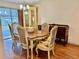 Charming dining area featuring a classic table set for six, adjacent to sun-drenched outdoor space at 209 Ann Ave, Dundee, FL 33838