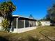 View of the home's screened porch and spacious backyard at 209 Ann Ave, Dundee, FL 33838