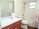 Bright bathroom featuring a combined shower and tub, a toilet, and a vanity with countertop sink at 2111 Groveglen S Ln, Lakeland, FL 33813