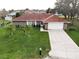 Charming single-story home showcasing a red roof, brick facade, and green front yard at 2111 Groveglen S Ln, Lakeland, FL 33813