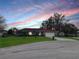 Charming single-story home with well-maintained lawn, palm trees, and a two-car garage at sunset at 2111 Groveglen S Ln, Lakeland, FL 33813