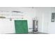 Well-lit garage featuring shelving, a water heater, and a white door at 2111 Groveglen S Ln, Lakeland, FL 33813