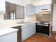 Well-lit kitchen featuring modern stainless steel oven, double sinks, and light blue cabinets at 2111 Groveglen S Ln, Lakeland, FL 33813